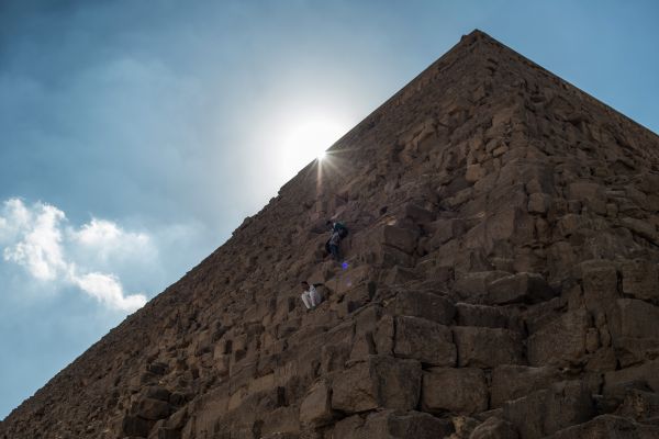 资料图片：2015年11月11日在埃及吉萨省拍摄的攀爬哈夫拉金字塔的游客。新华社记者潘超越摄