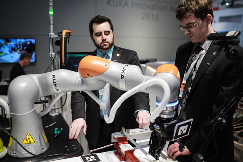 资料图：工作人员在德国库卡机器人公司展区展示机器人手臂。 新华社记者张帆摄