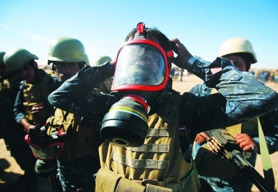 16日，一名伊拉克警察在摩苏尔以南约60公里的盖亚拉军事基地试戴防毒面具。