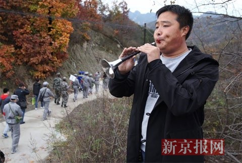 男子为“红军战士”吹起《十送红军》。新京报记者 尹亚飞 摄