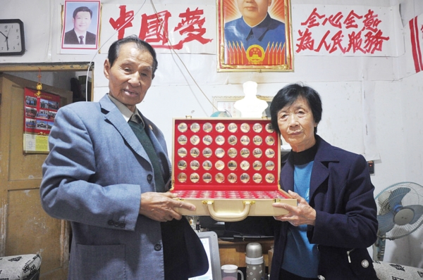余志华老人(左)向记者展示他的收藏品。