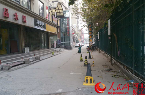 图为石家庄东里苑小区外西侧道路存在乱设地桩问题。