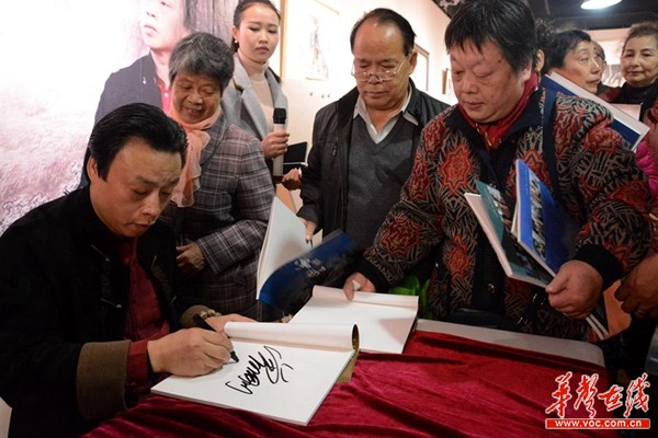 图为曾刚为慕名而来的“刚丝”们签名。