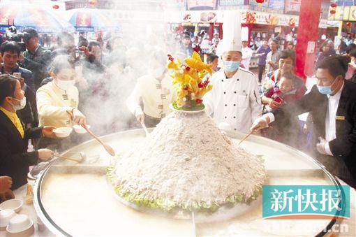 ■在广州国际美食节番禺主会场,番禺宾馆的厨师制作出直径达1.8米的“爬金山”,吸引众多市民围观品尝。    新快报记者　毕志毅/摄