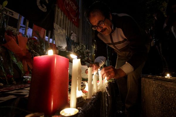 11月26日，在智利首都圣地亚哥，一名男子在古巴大使馆外点燃蜡烛，悼念菲德尔·卡斯特罗。新华社发