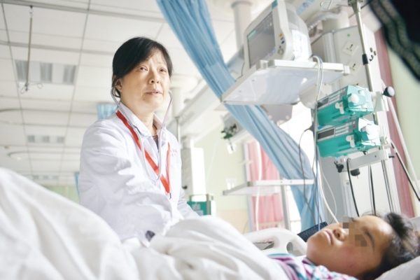 贵州省妇幼保健院妇产科重症监护科主任刘兰在给一名产妇做体检。