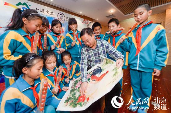 活动现场,孩子们一边吃着冰糖葫芦一边听着关于年画的民俗。