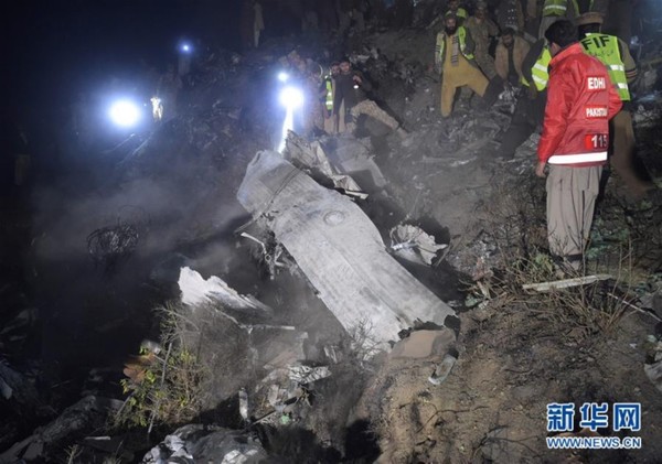 12月7日，在巴基斯坦北部赫韦利扬地区，巴基斯坦士兵和志愿者在飞机残骸中寻找遇难者遗体。