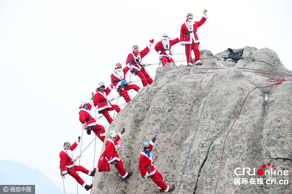 　　当地时间2016年12月18日，韩国京畿道杨州市，圣诞节前一周，登山俱乐部的会员们身着圣诞老人的服装，在北汉山国立公园集体登山。图片来源：视觉中国