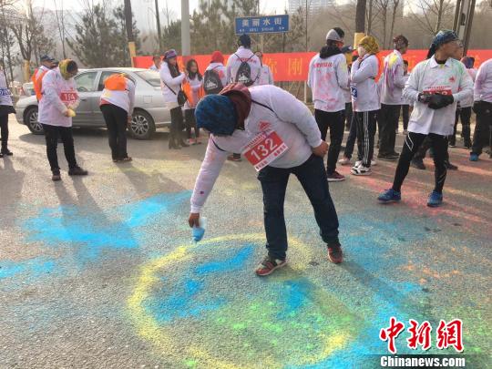 图为比赛选手用彩粉在路面绘画。张添福 摄