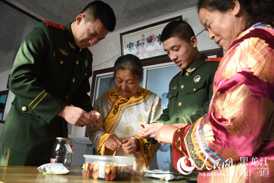 同江边防大队官兵陪赫哲族群众过腊八节。