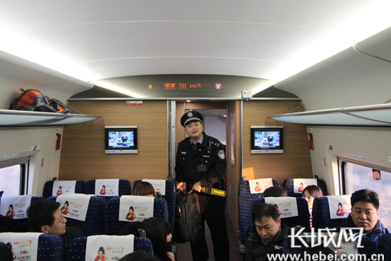 石家庄乘警支队乘警在高铁上为旅客演示行李安全存放。韩晓寒 摄