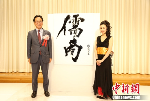 图为日本中华总商会会长严浩(左)与书法家在《儒商》书法作品前合影留念。尹法根 摄