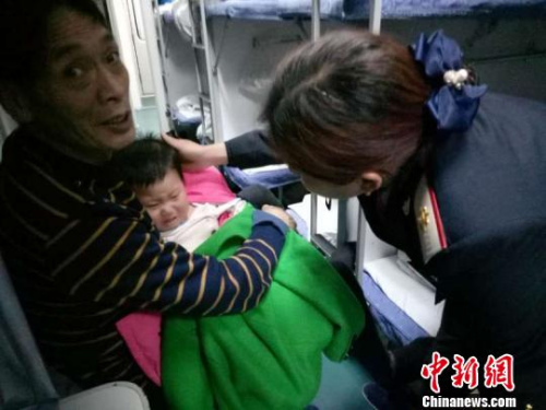 图为列车乘务员正在处置列车上的患病儿童。　王玉 摄