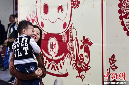 1月24日，广府年俗插画逗乐一对出行的母子。中新社记者 陈骥旻 摄