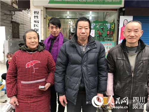 张加杰在鞋摊旁和家人合影。