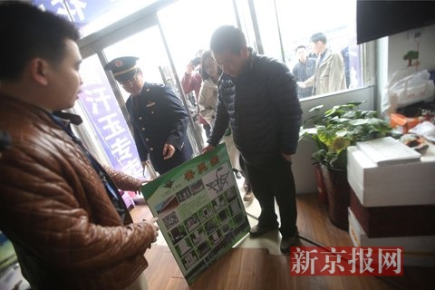 执法人员要求店主现场将不正规公墓宣传牌折断。新京报记者 王飞 摄