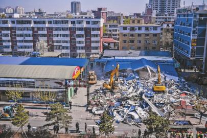 伴随着机械的轰鸣声，长春重庆路商圈最大违建全福农贸市场变成一堆废墟 新文化记者 郭亮 摄