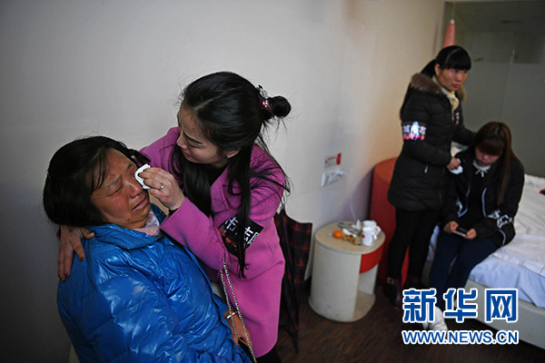 11月26日，心理疏导志愿者在事故现场附近的宾馆抚慰来自湖北的遇难者家属。新华社记者万象