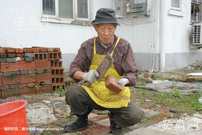 程东珍老人用砖铺垫小区坑洼处。