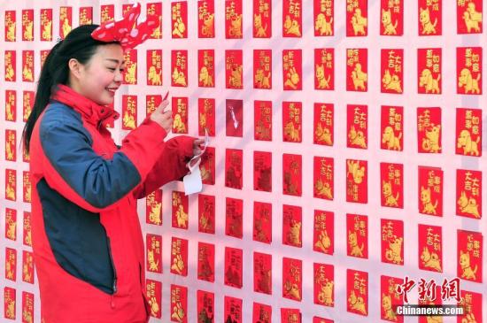 2月16日，大年初一，游客来到天津方特欢乐世界红包墙前抢包红。<a target='_blank' href='http://www.chinanews.com/'></p><p class=