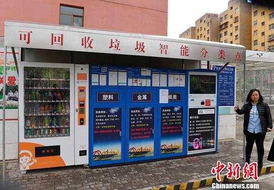 垃圾智能箱高2米、宽5米左右，代替人工进行回收、分类、称重垃圾等工作，该设备由会员操控机、垃圾分类回收箱、积分兑换机和遮雨棚组成。　杨艳敏摄