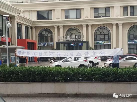 冯某的家属在摩拜楼前展示横幅