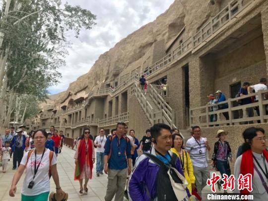8月是敦煌传统旅游旺季，大批游客前往敦煌莫高窟游玩。图为人流密集的莫高窟窟区。　闫姣摄