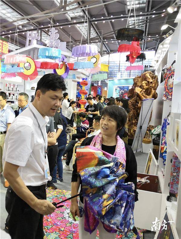 16日，参观者在惠州展区了解农民画的衍生产品。南方日报记者黄珊摄