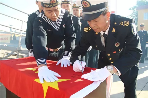 官兵纷纷在军旗上签下自己的名字。