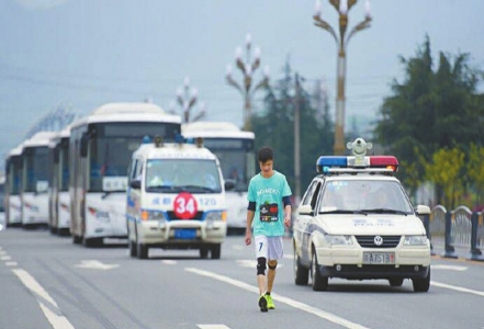 照片中,一个穿着蓝色t恤,白色短裤的男子,在警车,救护车和数辆收容车