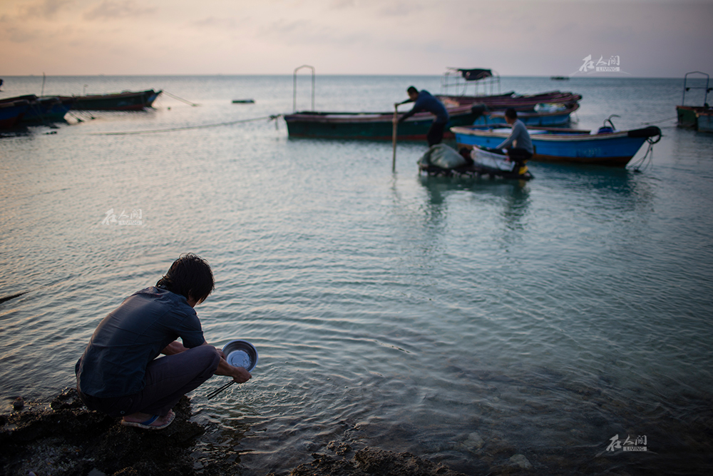 2016年4月16日,三沙市赵述岛海边,一位渔民在洗碗.
