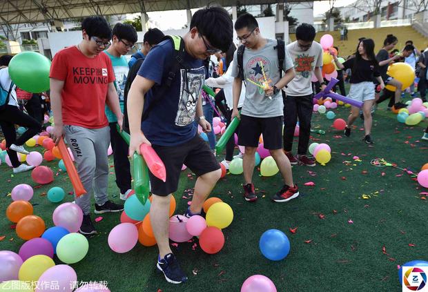 随即,操场上踩爆气球的噼啪声此起彼伏.图为男生在踩气球.