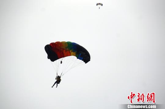 正文原标题:河南"空中飞人"3000米高空上演跳伞秀 图为运动员在空中