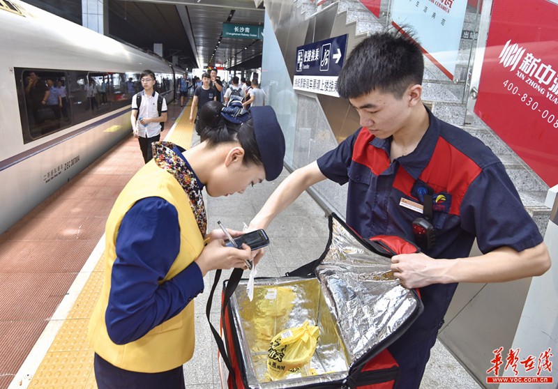 7月17日,长沙南站,网络订餐配送中心工作人员将外卖交给列车乘务员